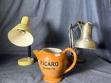 un petit pichet orange posé à côté d'une lampe sur une table