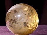 une boule de verre posée sur un tissu violet