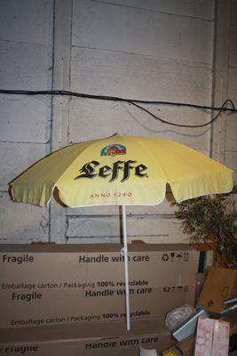 un parapluie jaune posé sur une charrette dans un entrepôt