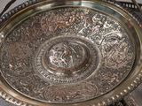 a silver plate with a design on it sitting on a table