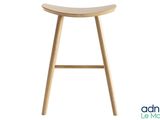 le tabouret est en bois et possède une assise incurvée