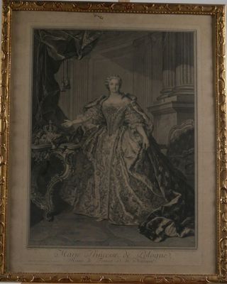 an old picture of a woman in a dress sitting in a chair