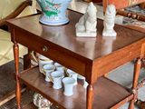 une petite table sur laquelle se trouve un vase, au milieu d'un salon