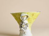 un petit vase dans lequel figure une femme tenant une fleur