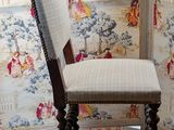 a chair that is sitting in front of a wallpapered wall