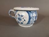 a blue and white vase with a lid on a table