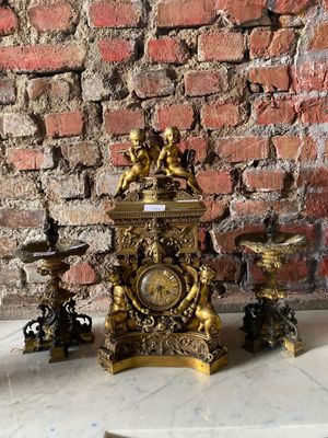 une horloge en or posée sur une table en marbre, près d'un mur en briques