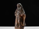 a bronze statue of a woman sitting on a chair
