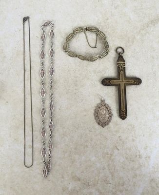 une croix, un collier et un bracelet posés sur une table