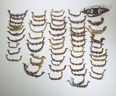 de nombreuses poignées en laiton anciennes sur un mur blanc