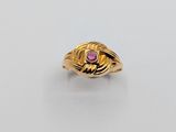 a close up of a gold ring with a pink stone