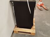 an image of a small black refrigerator in a garage
