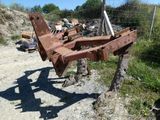 un tracteur rouillé au bord d'un chemin de terre