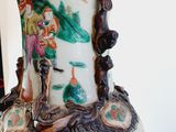a vase with a painting on it sitting on a table