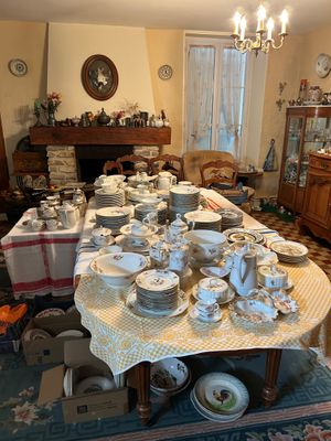 une salle à manger avec beaucoup de vaisselle et d'assiettes sur la table