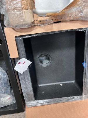 a black sink in the middle of a cardboard box