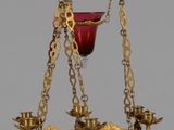 un verre doré et rouge suspendu à une chaîne dorée