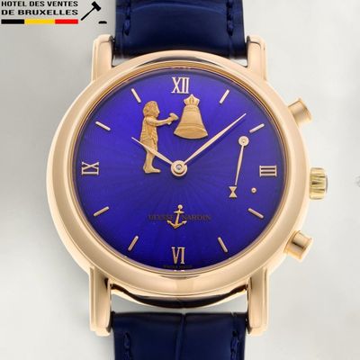 une image représentant une montre dorée et bleue ornée de chiffres romains