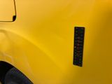 a close up of a yellow truck with a sticker on it ' s side