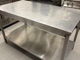 a large stainless steel table in the middle of a kitchen