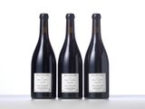 three bottles of wine are lined up on a table