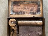 a small musical box with a clock inside of it