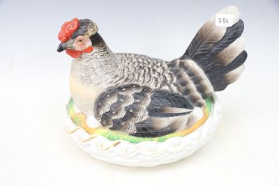 a figurine of a chicken sitting on a plate