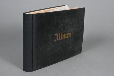 a black book with gold lettering sitting on top of a gray surface