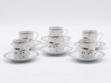 quatre tasses et soucoupes sont posées sur une surface blanche