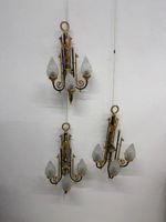 Ensemble de trois appliques à trois lumières en bronze.