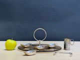 a silver plate with spoons and a green apple on it