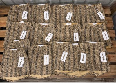 many bags of food sitting on top of a wooden pallet
