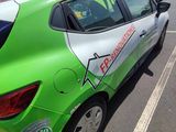 a green and white car parked on the side of the road