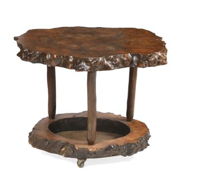 une image représentant une table en bois montée sur roulettes, dont le plateau est constitué d'une souche d'arbre