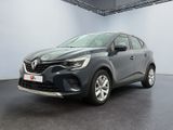 une voiture grise garée dans une grande pièce aux murs blancs