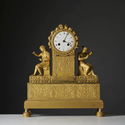 a gold clock sitting on top of a white table
