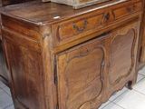 une commode en bois surmontée d'un miroir, dans une pièce