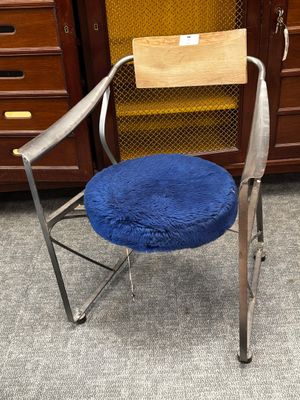 une chaise sur laquelle est posé un coussin bleu, dans une pièce