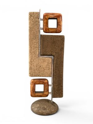 sculpture en liège et en métal posée sur un rocher, sur fond blanc