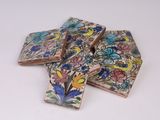 quatre carreaux ornés de fleurs et d'oiseaux sur un fond blanc