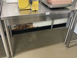 une table en acier inoxydable sur laquelle se trouve un bol de nourriture