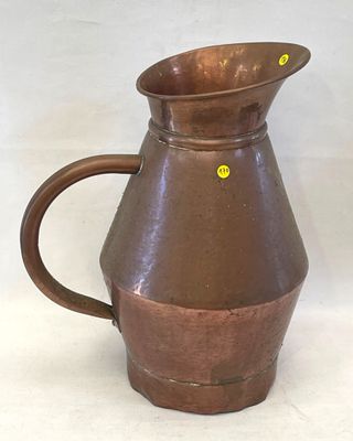 un pichet marron orné d'un point jaune