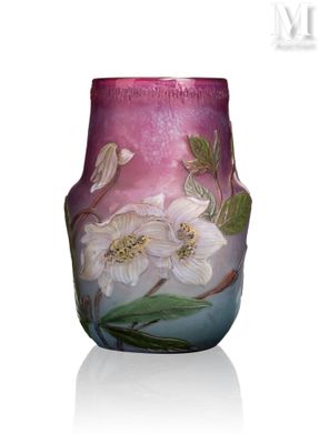 un vase avec des fleurs peintes dessus, posé sur une table