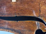 the back of a violin with a black handle on a wooden table