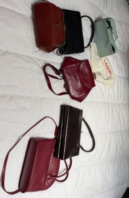 plein de sacs à main posés ensemble sur un lit