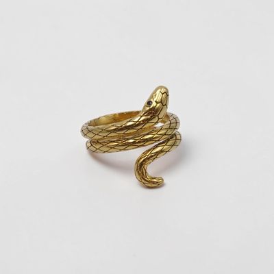 une image représentant une bague en forme de serpent dorée sur fond blanc