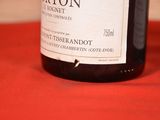 a bottle of wine sitting on a table with a red cloth