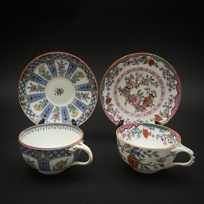 deux tasses et soucoupes ornées de motifs floraux sur fond noir