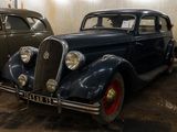 deux vieilles voitures garées l'une à côté de l'autre dans un garage