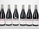 six bouteilles de vin rouge alignées sur une table